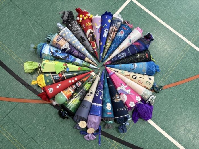 Schultüten liegen im Kreis auf dem Sporthallenboden.